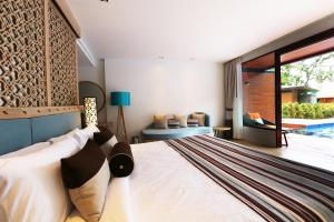 a bedroom with a large bed and a couch at AKIRA Lipe Resort in Ko Lipe