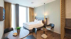 Schenkon的住宿－Lumen Apartments，酒店客房带一张床、一张桌子和椅子
