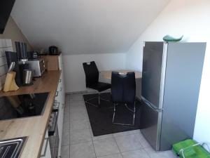 una pequeña cocina con mesa y nevera en Ferienwohnung Waldweg, en Grafenwiesen