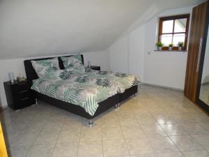 a bedroom with a bed with a comforter on it at Ferienwohnung Waldweg in Grafenwiesen