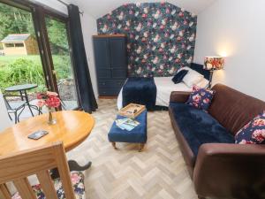 sala de estar con cama y sofá en Peony Cottage, en St Austell