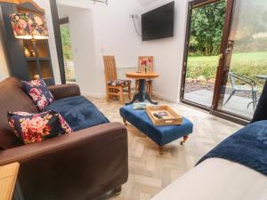 Sala de estar con 2 sofás y mesa en Peony Cottage, en St Austell
