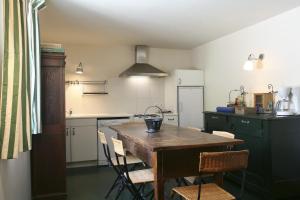 DonnazacにあるGites Les Vents Bleusの木製のテーブルと椅子のあるキッチン