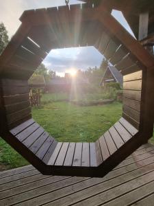 a circular window on a deck with the sun in the background at Norwegian saunahouse in Haapse