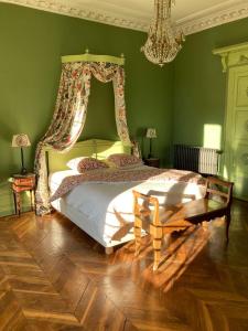 a green bedroom with a bed and a chandelier at La Villa Romaine 