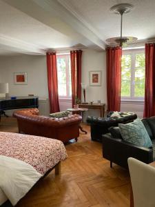 a living room with leather furniture and a piano at La Villa Romaine 