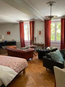 salon ze skórzanymi meblami i pianinem w obiekcie La Villa Romaine w mieście Montmirey-la-Ville