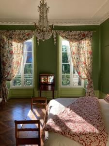 a bedroom with a bed and two windows at La Villa Romaine 