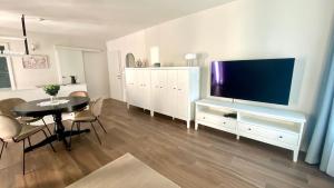 a living room with a table and a large television at Aria Apartments in Kojsko