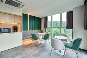 eine Küche und ein Esszimmer mit Tischen und Stühlen in der Unterkunft Hotel Square Ansan in Ansan