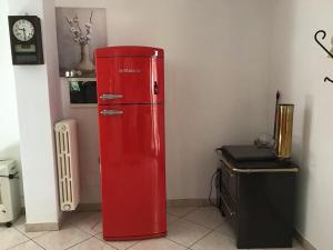 Casa Tre Fontane في مونسومانو: ثلاجة حمراء في غرفة بها ساعة