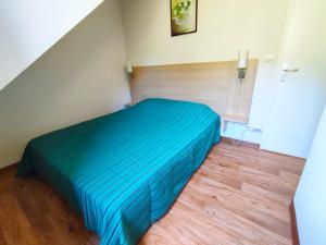 a bedroom with a bed with a blue comforter at Chez Marie-Laure, T3 résidence les Jardins de Ramel, parking, balcon, 4 personnes in Luchon