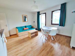 a living room with a blue couch and a table at Chez Marie-Laure, T3 résidence les Jardins de Ramel, parking, balcon, 4 personnes in Luchon