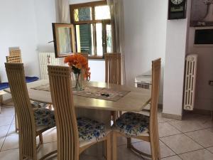 tavolo da pranzo con sedie e vaso di fiori di Casa Tre Fontane a Monsummano