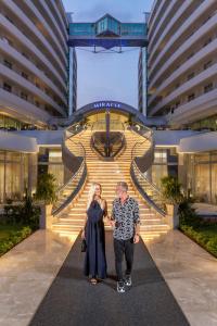 a man and woman standing in front of a building at Miracle Resort Hotel in Lara