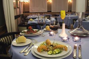 - une table avec des assiettes de nourriture et des verres de vin dans l'établissement Hotel Des Geneys, à Bardonnèche