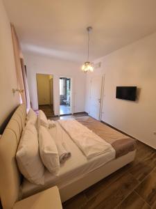 ein großes Bett in einem Zimmer mit einem TV in der Unterkunft Opera apartments in Tivat