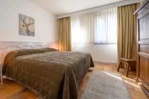 um quarto de hotel com uma cama e uma janela em Alpesmith - Bike & Ski apartments em Bardonecchia