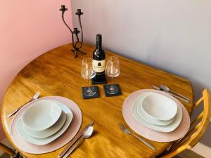 a wooden table with plates and a bottle of wine at Almarie in Fort William