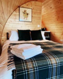 1 dormitorio con 1 cama con toallas en The Pods at Streamvale, en Gilnahirk