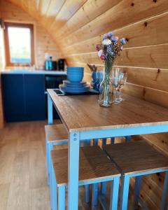 una cucina con un tavolo con un vaso di fiori sopra di The Pods at Streamvale a Gilnahirk