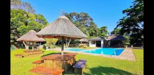 a resort with a pool with a table and umbrella at Eden Wilds 38 in Port Edward