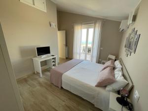 Schlafzimmer mit einem Bett und einem Schreibtisch mit einem TV in der Unterkunft Casa Vacanze Lago Blu in Trevignano Romano
