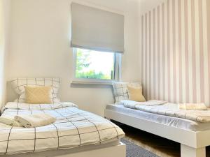 two beds in a room with a window at APARTAMENT NA WZGÓRZU in Lidzbark Warmiński