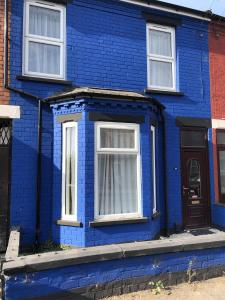 uma casa azul com janelas brancas e uma porta em Blue house em Lincoln