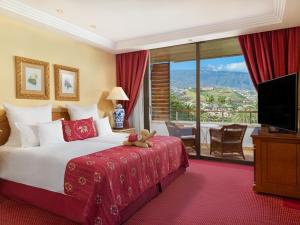 a hotel room with a bed with a teddy bear on it at Hotel Botanico y Oriental Spa Garden in Puerto de la Cruz