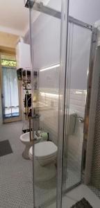 uma casa de banho com um WC e uma cabina de duche em vidro. em Il Giardino di Maura - Aemme2 em Recanati