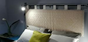 Bett mit Kopfteil und Kissen im Zimmer in der Unterkunft Il Giardino di Maura - Aemme2 in Recanati