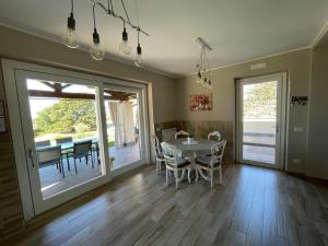 une salle à manger avec une table et des chaises ainsi qu'une terrasse dans l'établissement Casa Vacanze Lago Blu, à Trevignano Romano