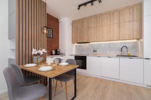 a kitchen with a wooden table and chairs in a room at Lwowska 10 Residence Apartment Cracow in Krakow