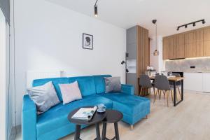 uma sala de estar com um sofá azul e uma mesa em Lwowska 10 Residence Apartment Cracow em Cracóvia