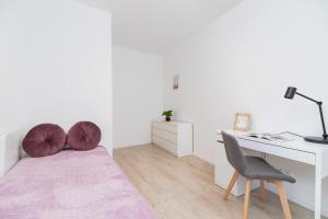 um quarto com uma cama, uma secretária e uma cadeira em Lwowska 10 Residence Apartment Cracow em Cracóvia