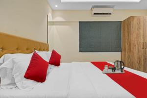 um quarto com uma cama grande e almofadas vermelhas em Hotel Sunrise Juhu em Mumbai