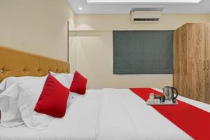 a bedroom with a large bed with red pillows at Hotel Sunrise Juhu in Mumbai