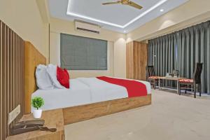 a bedroom with a large bed and a desk at Hotel Sunrise Juhu in Mumbai