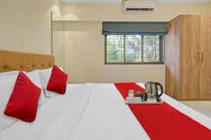 1 dormitorio con 1 cama grande con almohadas rojas en Hotel Sunrise Juhu, en Bombay