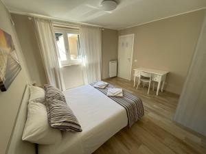 Casa Vacanze Lago Blu في ترفيجنانو رومانو: غرفة نوم بسرير ونافذة وطاولة