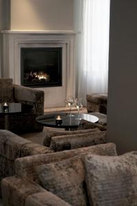 a living room with a table and chairs and a fireplace at Avenue Hotel Copenhagen by Brøchner Hotels in Copenhagen