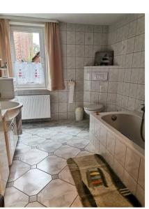 łazienka z wanną, toaletą i oknem w obiekcie Gästehaus Reiterlodge auf dem Land 