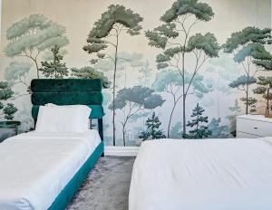 1 dormitorio con 2 camas y un mural de árboles en Walk to Dania Beach Holiday Retreat Miami Pool en Dania Beach