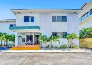 uma casa branca com palmeiras em frente em Walk to Dania Beach Holiday Retreat Miami Pool em Dania Beach