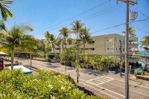 una strada vuota di fronte a un edificio con palme di Kona Bali Kai #232 a Kailua-Kona