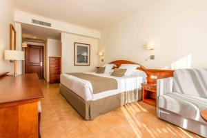 een hotelkamer met een bed en een stoel bij Valentin Sancti Petri in Chiclana de la Frontera