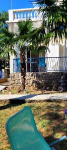 a green object in the grass in front of a house at Studio Luka in Crikvenica