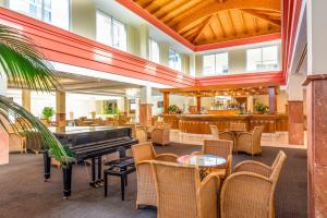 a lobby with a piano and tables and chairs at Valentin Sancti Petri in Chiclana de la Frontera