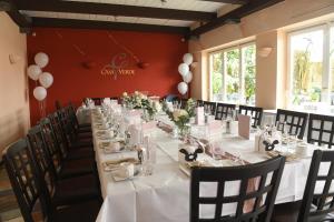 a long table in a room with white tables and chairs at Hotel Casa Verde in Trier